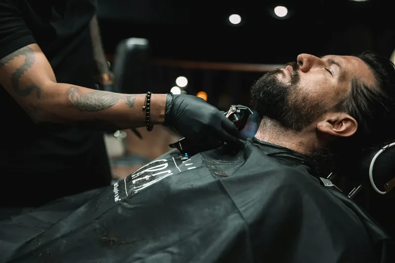 Il barbiere rifinisce la barba di un cliente